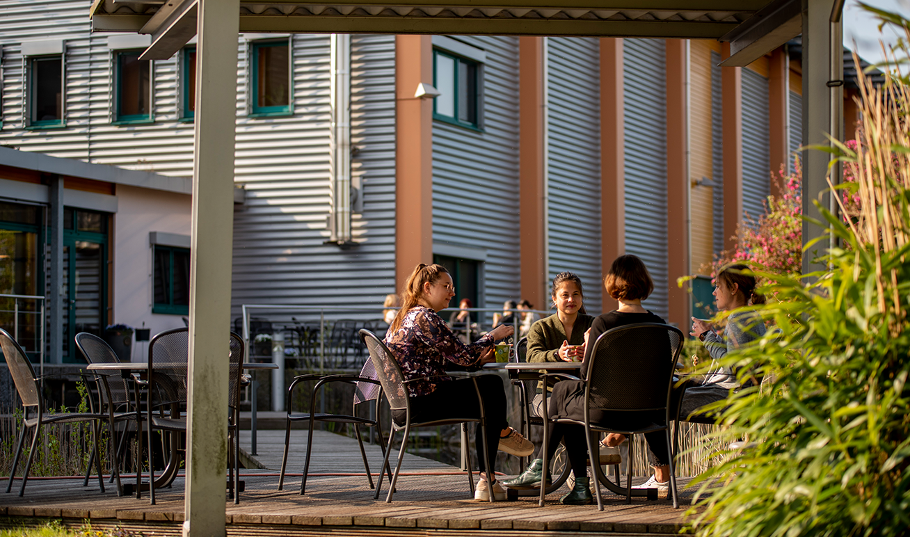 Menschen sitzen an einem Tisch im Außenbereich unseres Bistros in Diepholz